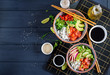 Hawaiian salmon fish poke bowl with rice, avocado, paprika, cucumber, radish, sesame seeds and lime. Buddha bowl. Diet food. Top view
