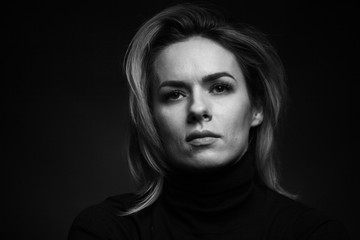 Dramatic black and white portrait of a beautiful woman on a dark background