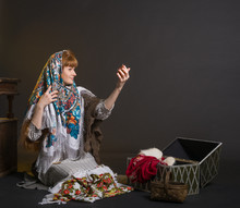 A Young Russian Woman Wears A Traditional Scarf On Her Head Looking In The Mirror.