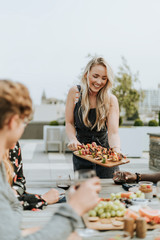 Woman serving vegan barbecue to her friends