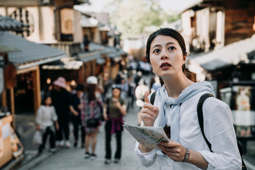 Wall Mural - woman tourist holding map pointing to direction