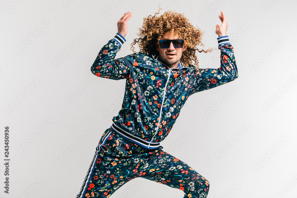 Excited adult funny man in stylish vintage clothes posing on white studio background. 80s fashion. Funky guy in tracksuit and sunglasses expressive indoor unusual portrait. Shouting cheerful male. - obrazy, fototapety, plakaty 