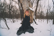 Depressed and lonely woman crying in forest in winter.