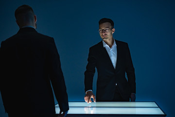 Poster - The two businessmen working with a sensor screen in the dark room