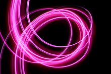 Light Painting, Long Exposure Photography, Vibrant Neon Pink Swirls Of Color Against A Black Background