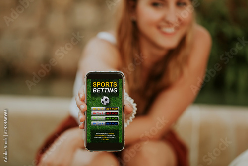Fotografía Sports betting website in a mobile phone and woman holding the device in the hand