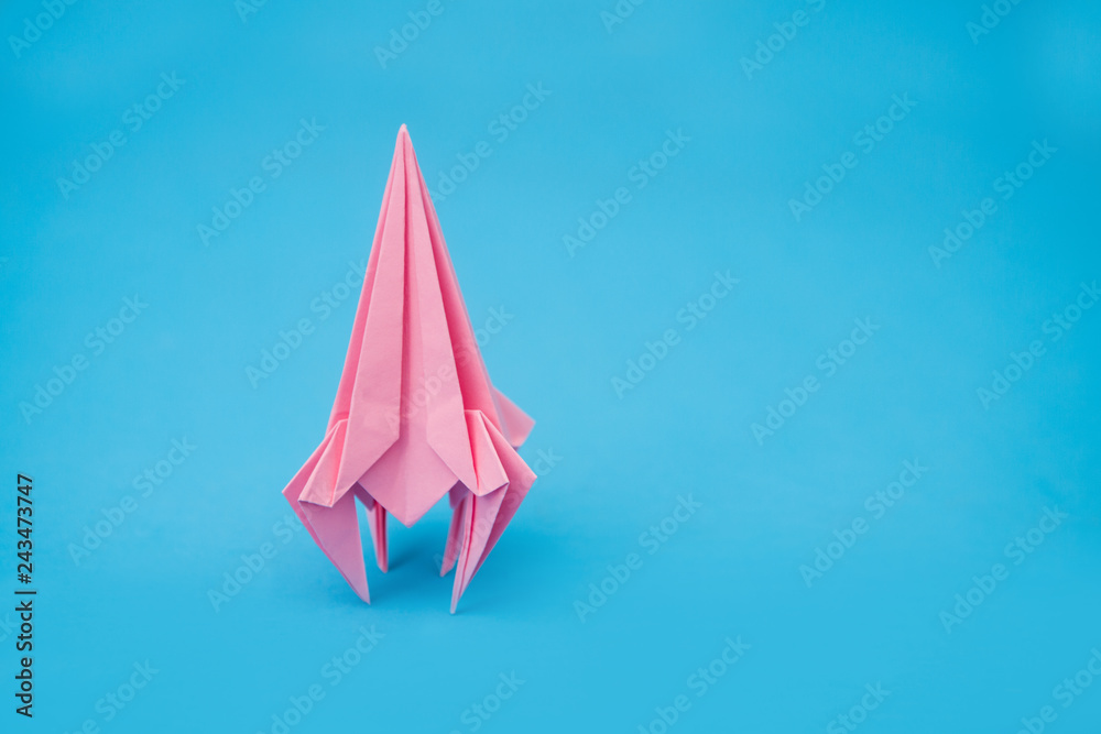 rocket from paper of origami on a blue background - obrazy, fototapety, plakaty 