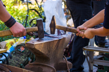 Wall Mural - blacksmith performs the forging of hot glowing metal on the anvil