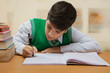 © IndiaPix - Young schoolboy doing his writing homework on the table