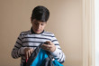 © IndiaPix - Boy packing backpack with school stationery supplies