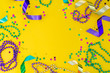 canvas print picture - Mardi gras carnival concept - beads on yellow background, top view