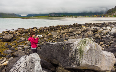 Wall Mural - Tourist with camera on Skagsanden Beach Lofoten Norway