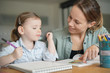 © goodluz - Mother and young daughter drawing and reading together at home