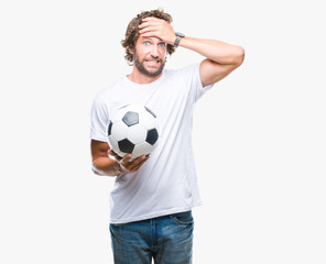 Canvas Print - Handsome hispanic man model holding soccer football ball over isolated background stressed with hand on head, shocked with shame and surprise face, angry and frustrated. Fear and upset for mistake.