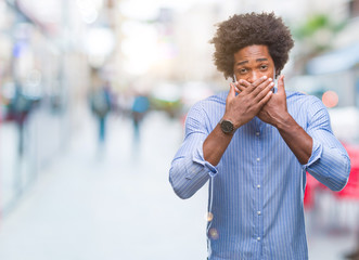 Poster - Afro american man over isolated background shocked covering mouth with hands for mistake. Secret concept.