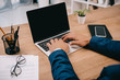 © LIGHTFIELD STUDIOS - cropped view of businessman typing on laptop at workplace with documents and smartphone