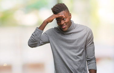 Wall Mural - Young african american man over isolated background very happy and smiling looking far away with hand over head. Searching concept.