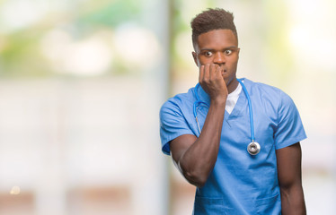 Poster - Young african american doctor man over isolated background wearing surgeon uniform looking stressed and nervous with hands on mouth biting nails. Anxiety problem.