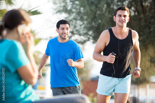 Fotografija Smiling sportsmen are joggning race in time warm-up