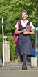 © dtiberio - Female Student Wearing Uniform Walking On Sidewalk