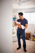 © Monkey Business - Proud Hispanic father holding his four month old child at home, seen from doorway, vertical