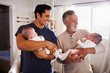 © Monkey Business - Young Hispanic man and his senior father holding his two baby boys at home