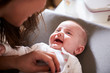 © Monkey Business - Happy four month old baby boy on changing table looking up at his mum, over shoulder view, close up