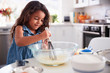© Monkey Business - Young Hispanic girl making a cake in the kitchen on her own, close up
