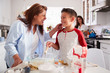 © Monkey Business - Pre-teen boy making a cake in the kitchen with his grandmother, his mum standing in the background