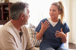 © Monkey Business - Female healthcare worker sitting with a senior Hispanic man in his living room during a home visit