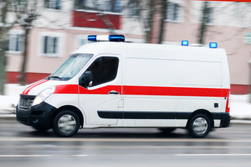 winter snow. Ambulance van on the highway, emergency lighting, blurred motion