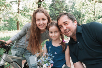 portrait of parents with their little daughter on a walk