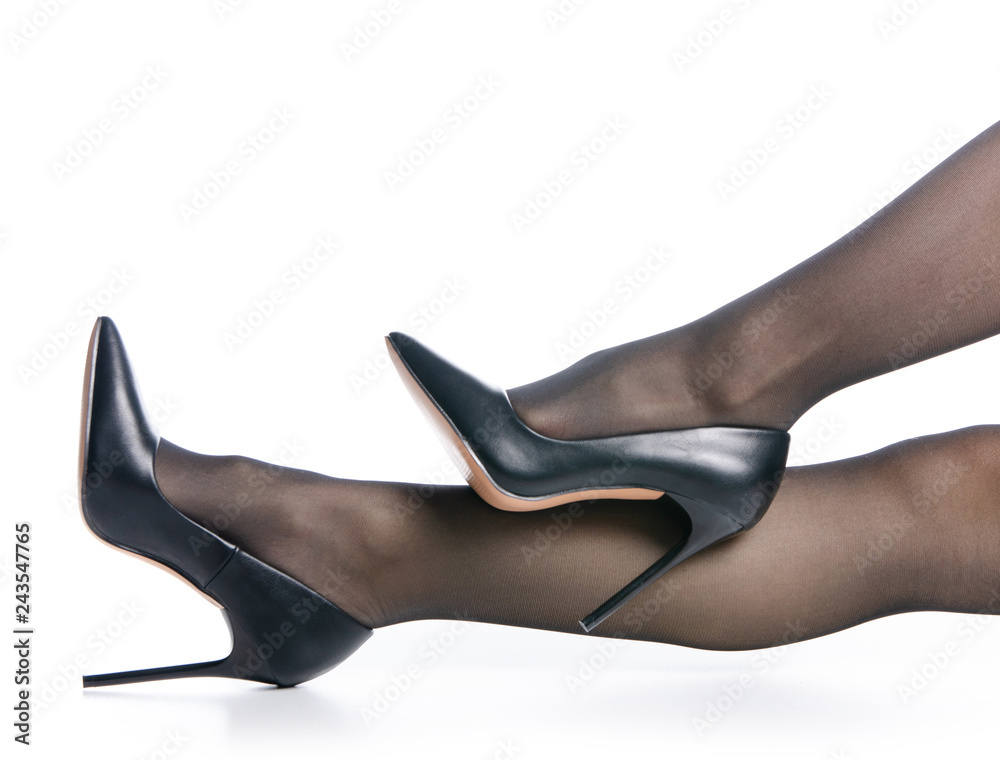 Female legs in black high heels shoes black stockings fashion on white background isolation Adobe Stock