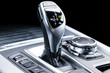 Automatic gear stick of a modern car. Modern car interior details. Close up view. Car detailing. Automatic transmission lever shift. Black leather interior with stitching.