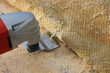 © Ilya - Removing the old carpet from floor with a power tool electric chisel renovator, repair in the apartment