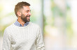 © Krakenimages.com - Adult hispanic man wearing winter sweater over isolated background looking away to side with smile on face, natural expression. Laughing confident.