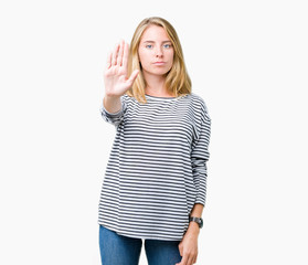 Beautiful young woman wearing stripes sweater over isolated background doing stop sing with palm of the hand. Warning expression with negative and serious gesture on the face.