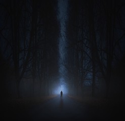 Surreal horror scene with alone strange man in dark night forest