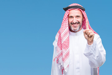 Senior arab man wearing keffiyeh over isolated background showing and pointing up with finger number one while smiling confident and happy.