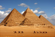 canvas print picture - pyramids giza cairo in egypt with camel caravane panoramic scenic view
