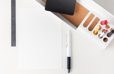 Poster - Top view white paper note on modern office stationery on white table.pencil, notepad,ruler,pen and pencil box with plant.Mock up paper note for display of design or content.