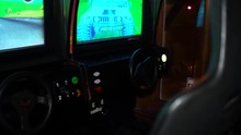 Shot Of An Old Arcade Game Where You Sit In A Car Seat To Play. SLOW MOTION