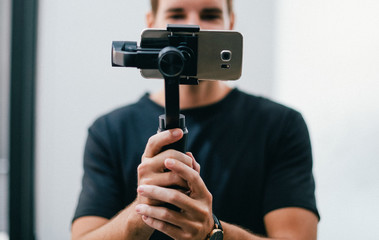 Poster - Man holding a gimbal with a phone