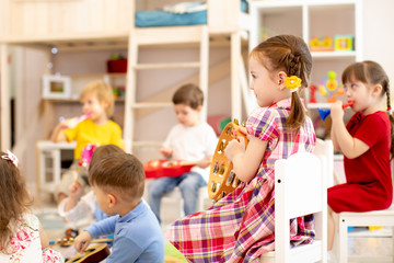 Group of preschooler children play musical toys at kindergarten