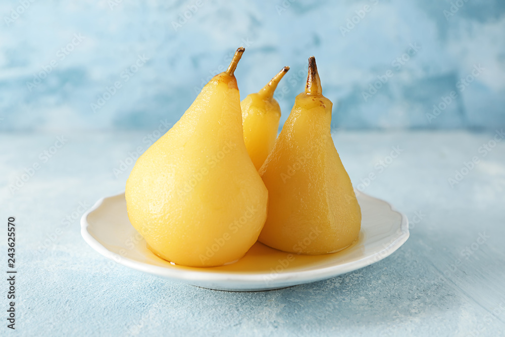 Plate with delicious poached pears in wine on color table