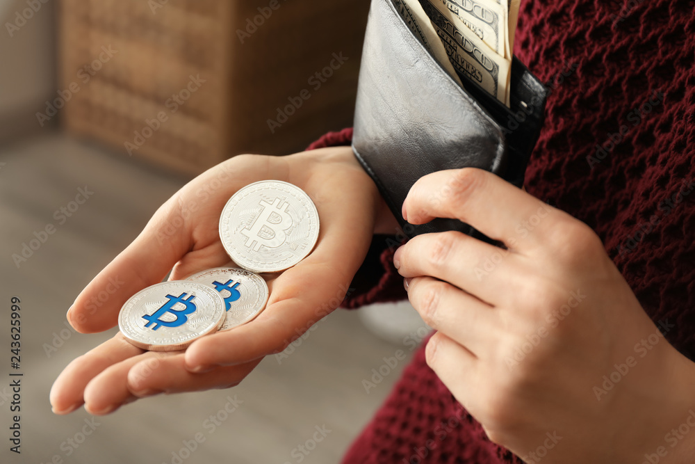 Woman holding wallet and bitcoins, closeup