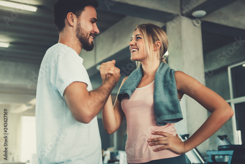 Fotografía Attractive young couple handshaking after workout in fitness gym