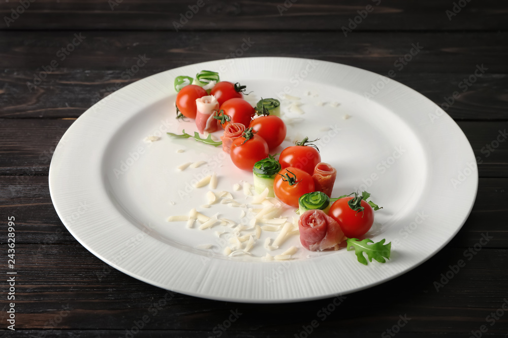 Plate with tomatoes and cheese on dark wooden background