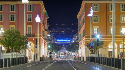 Wall Mural - Night cityscape with moving tram on Massena Square in downtown timelapse