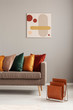 © Photographee.eu - Magazine rack next to beige sofa with pillows in stylish living room interior